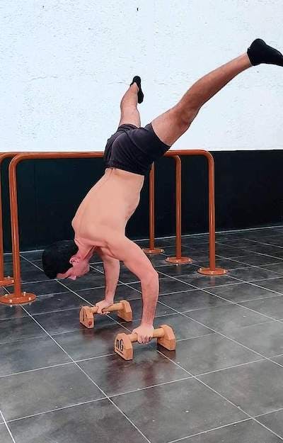 Handstand negative to straddle with bent elbows
